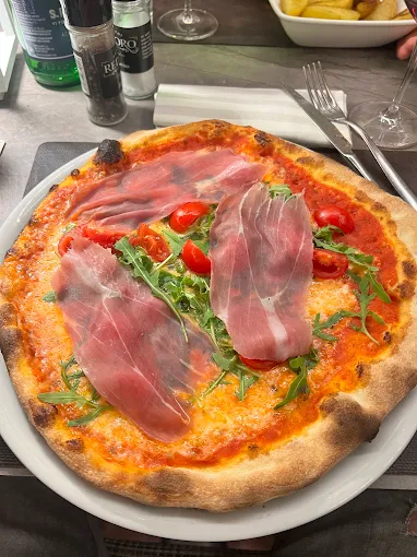 Pizza con crudo di Parma, rucola e pomodorini